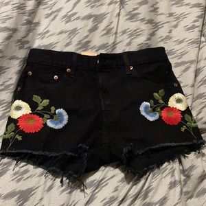 Super cute black jean shorts with flower details.